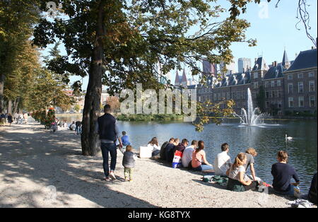 Junge Leute und Touristen, die im Sommer Hofvijver Teich, Den Haag, Niederlande. Binnenhof historischen Parlamentsgebäude & Sitz der Regierung Stockfoto
