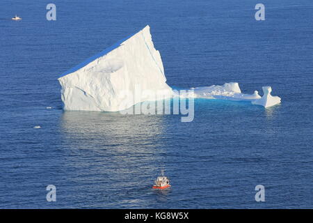 Schiff nähert sich einem Eisberg in den Atlantischen Ozean, nur außerhalb der verengt, St John's Hafen, St. John's, Neufundland und Labrador. Stockfoto