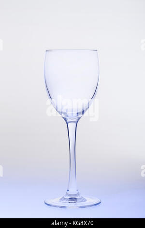 Leere Glas Wein auf Farbübergang Hintergrund. Stockfoto