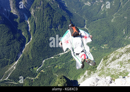 Diese wingsuit Base Jumper nur verstärkt über die Klippe und ist mutig Tauchen hinab in die ungewiss. Bald muss er seinen Fallschirm zu retten. Stockfoto