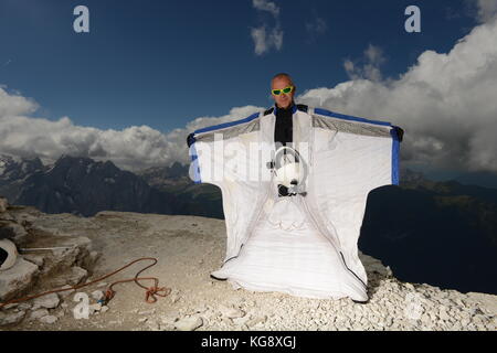 Diese wingsuit Base Jumper überprüft seine Klage vor dem Springen den Berg. Die Konzentration ist hoch, um sicherzustellen, dass keine Fehler passieren. Stockfoto