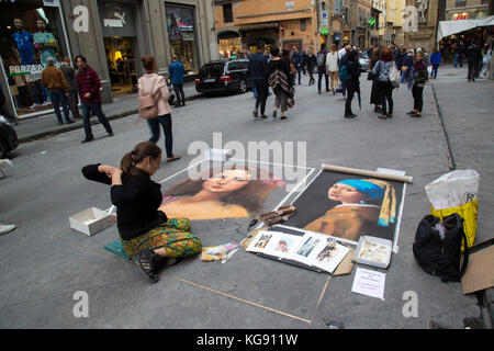 Street artist ausdehnen und dabei die Kreide Artwork auf dem Gehweg von einem geschäftigen Florentiner Straße Stockfoto