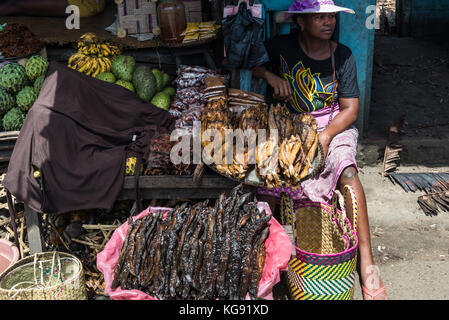 Eine madagassische Frau sitzen durch ihren Stall Verkauf von getrockneten Fisch, Aale und andere lokale Produkte auf dem Markt. Madagaskar, Afrika. Stockfoto