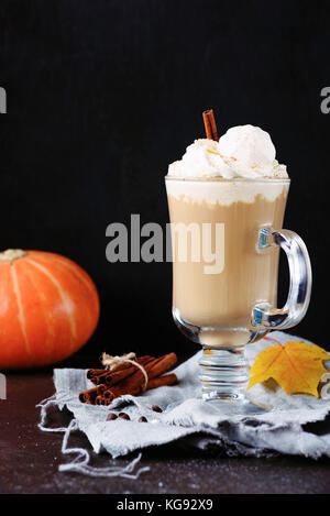 Pumpkin spice Latte oder Kaffee mit Sahne, Zimt und Marshmallows in Glas mug über schwarzen Hintergrund. Vertikale, kopieren Platz für Text Stockfoto