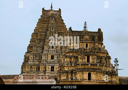 Geschnitzte gopuram Der virupaksha Temple, die auch als Pampavathi Tempel, Hampi, Karnataka, Indien bekannt. Die kleineren inneren gopura und die Mandapa Stockfoto