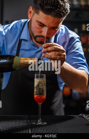 Barkeeper Vorbereitung einer Champagner Cocktail mit Rose jam Stockfoto