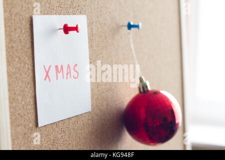 Weihnachten Wort auf Kork Brett und rote Christbaumkugel Konzept Stockfoto