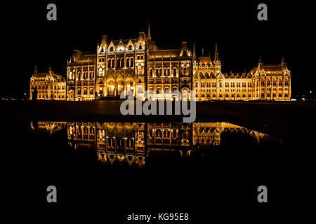 Ungarn, Budapest, ungarischen Parlament ist Abends beleuchtet mit Spiegelbild im Wasser Stockfoto