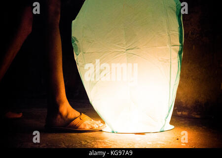 Junge halten Sie Grünbuch Laterne mit sandled Füße. Chinesische lanters haben eine Tradition der Makar Sankranti und Diwali werden Stockfoto