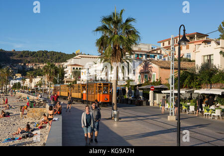 Touristen entspannen am Strand, hölzerne Straßenbahn fährt mit der Straßenbahn, Port de Soller, Mallorca, Balearen, Spanien. Stockfoto