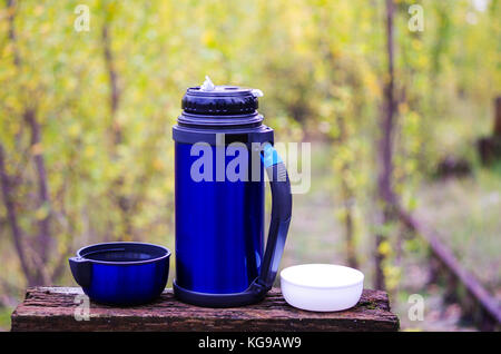 Thermoskanne für Getränke. Thermosflasche mit zwei Tassen. Mit einer Thermoskanne auf die Natur. Camping mit einer Thermoskanne. Stockfoto