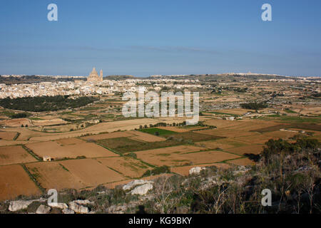 Blick nach Norden über ein ländliches Tal in Richtung des Dorfes Xewkija in Gozo, Malta. Gozitanische Landschaft und Skyline. Stockfoto