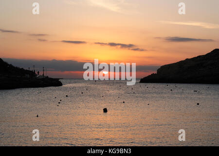 Sonnenuntergang über dem Mittelmeer, wie vom Badeort Xlendi auf Gozo, Malta betrachtet Stockfoto