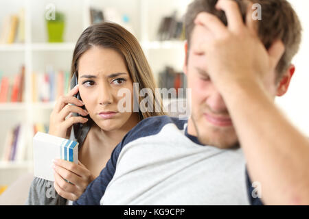 Besorgt, Frau, Doktor Informationen anfordern sitzen auf einer Couch im Wohnzimmer in einem Haus innen Stockfoto