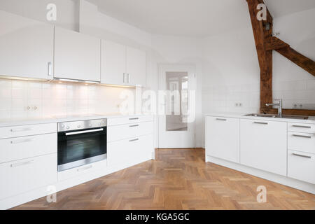 Moderne, weiße Küche in Penthouse mit Holzboden Stockfoto