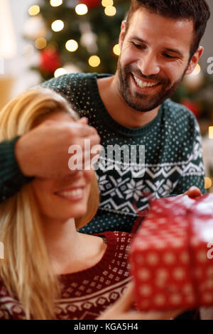 Lächelnd mann Box geben mit Weihnachtsüberraschung zu Frau Stockfoto