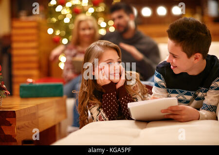 Aufgeregt Mädchen mit jungen Weihnachten Wünsche auf Papier schreiben Stockfoto
