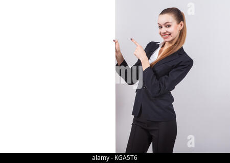 Mädchen in einem Anzug steht neben der Vorstand für den Text ein Stockfoto