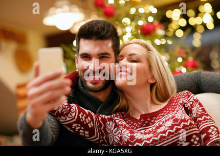 Lächelnd romantisches Paar unter selfie Bild mit Smartphone zu Hause Stockfoto