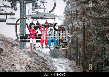 Skilift Verkehr Familie Skifahrer und Snowboarder im Holiday in verschneiten Berg Stockfoto