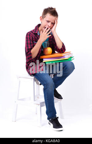 Müde Schüler europäischen Aussehen in T-Shirt und Jeans sitzen o Stockfoto