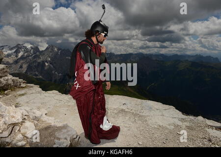 Diese wingsuit Base Jumper überprüft seine Klage vor dem Verlassen der Berg. Die Konzentration ist hoch, um sicherzustellen, dass keine Fehler passieren. Stockfoto