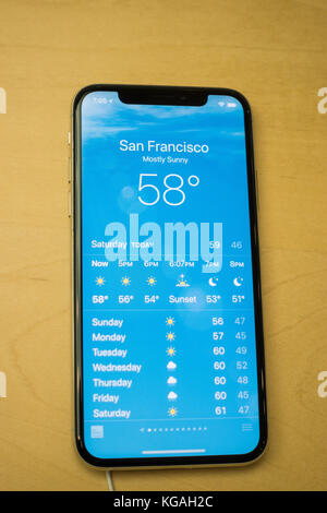 Iphone x-Vorderansicht des neuesten Iphone App zeigt das Wetter und die aktuelle Temperatur und Wettervorhersage für San Francisco, Ca Stockfoto