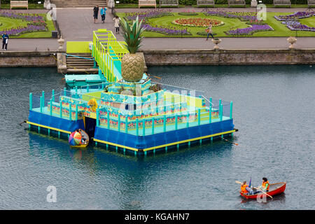 Im Bild: Hochwinkelblick auf den Palm House Pond mit der „schwimmenden Ananasinsel“. Kew Gardens startet das Sommerfestival „Incredibles“ mit einem „Tutti Frutti Boating Experience“ am Palm House Pond, entworfen von Bompas & Parr, einem „Bouncy Carrot Patch“ und einer „Alice im Wonderland“-inspirierten Teeparty im Rosengarten. Das Festival findet vom 25. Mai bis 3. November 2013 statt, die Bootstouren enden am 1. September. Stockfoto