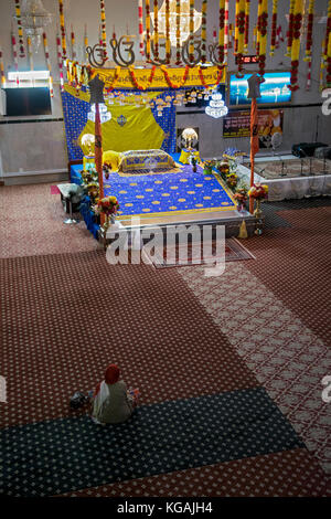 Eine einzelne Anbeter in der Baba Makhan Shah Lobana Sikh Center auf 101 Avenue in Richmone Hill, Queens, New York City Stockfoto