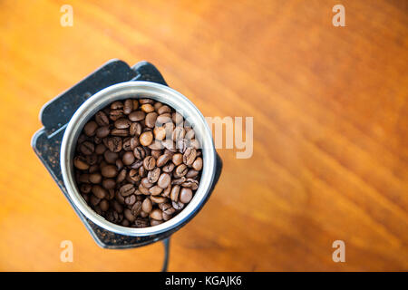 Mokka Kaffeebohnen gegossen auf eine elektrische Kaffeemühle bereit für Schleifen mit kopieren. Ansicht von oben. Stockfoto