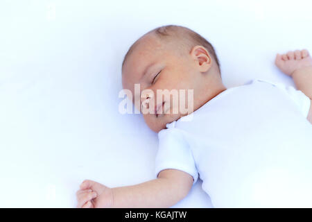Neugeborenes Baby boy Schlafen auf dem Rücken auf einer weißen Decke Stockfoto