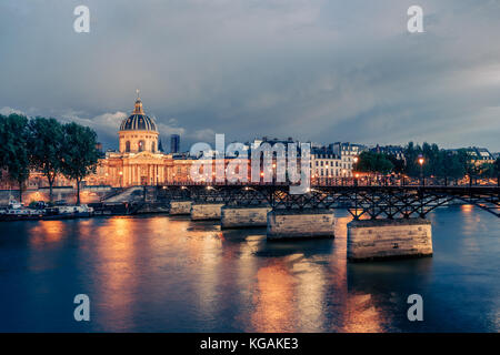 Berühmte Pont des Arts und academie Francaise in Paris bei Nacht. spektakuläre Stadtbild mit dramatischen Sonnenuntergang Himmel. Stockfoto