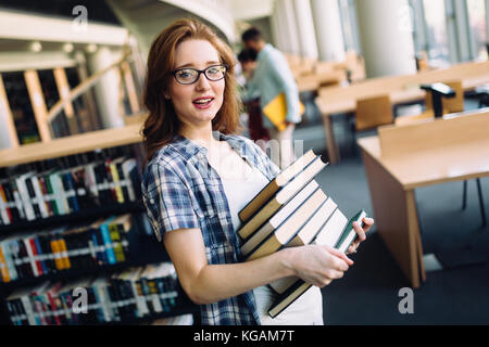 Porträt der jungen Studentin in der Bibliothek Stockfoto
