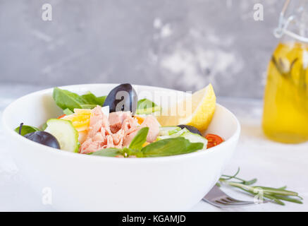 Salat mit Thunfisch, Ei und Oliven in einer weißen Schüssel. Stockfoto