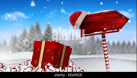Digital composite von Geschenken und hölzernen Wegweiser in Weihnachten Winter Landschaft und Santa hat Stockfoto