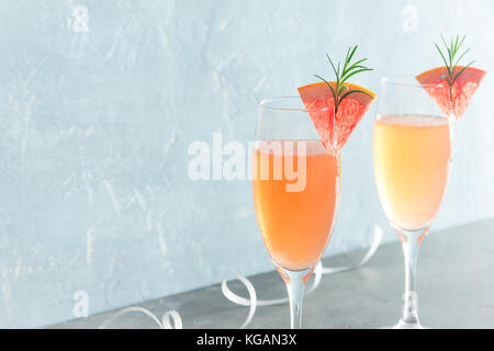 Mimosa festliches Getränk - Champagne Cocktail Mimosa mit Grapefruit und Rosmarin für Party, Kopie Raum Stockfoto