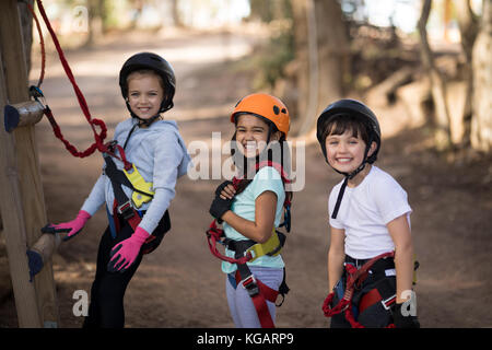 Portrait von Happy Kids vorbereiten für Zip Line an einem sonnigen Tag Stockfoto