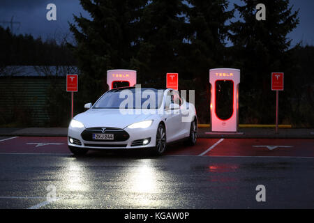 PAIMIO, Finnland - 14. NOVEMBER 2015: Tesla Model S Elektroauto kommt an der Paimio Tesla Kompressor Station in der Nacht zum Aufladen. Tesla Supercha Stockfoto