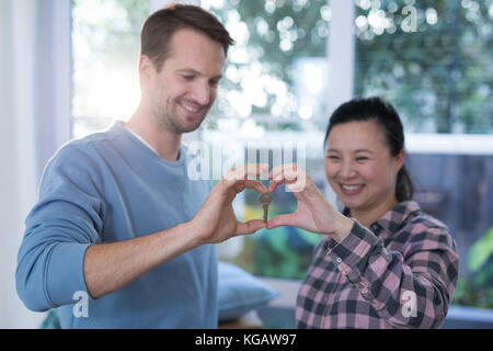 Paar, Herzform mit Händen im neuen Zuhause Stockfoto