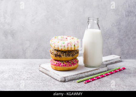 Bunte Donuts Turm und Milch in der Flasche. Stockfoto