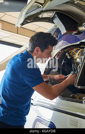 Männliche aero Engineer, der an Helikopter im Hangar Stockfoto