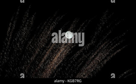 Ein 99% Mond mit Feuerwerk im Vordergrund über Whitley Bay, Tyne und Wear. Stockfoto
