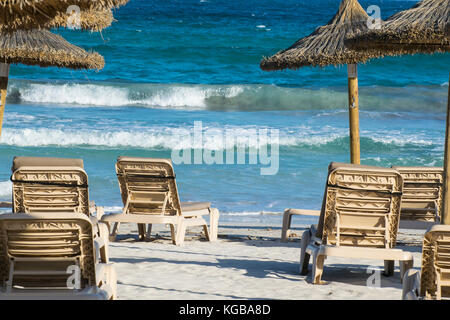 Liegen und Sonnenschirme am Strand von S'illot, Mallorca, Spanien Stockfoto