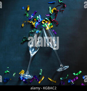 Zwei Sektgläser auf schwarzem Hintergrund mit buntem Konfetti. Party und Feier Konzept Stockfoto