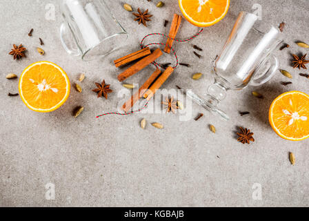 Weihnachten heiße Getränke Rezepte, von Zutaten für Glühwein: zwei Glas Tassen, Gewürze, orange. grauen Stein Hintergrund, Ansicht von oben Raum Stockfoto