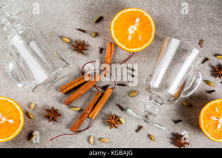 Weihnachten heiße Getränke Rezepte, von Zutaten für Glühwein: zwei Glas Tassen, Gewürze, orange. grauen Stein Hintergrund, Ansicht von oben Raum Stockfoto
