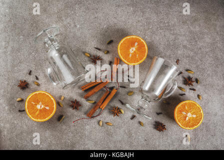 Weihnachten heiße Getränke Rezepte, von Zutaten für Glühwein: zwei Glas Tassen, Gewürze, orange. grauen Stein Hintergrund, Ansicht von oben Raum Stockfoto