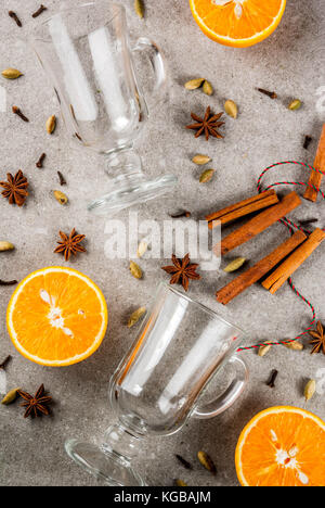 Weihnachten heiße Getränke Rezepte, von Zutaten für Glühwein: zwei Glas Tassen, Gewürze, orange. grauen Stein Hintergrund, Ansicht von oben Raum Stockfoto