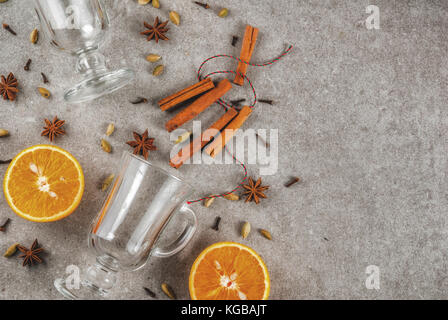 Weihnachten heiße Getränke Rezepte, von Zutaten für Glühwein: zwei Glas Tassen, Gewürze, orange. grauen Stein Hintergrund, Ansicht von oben Raum Stockfoto