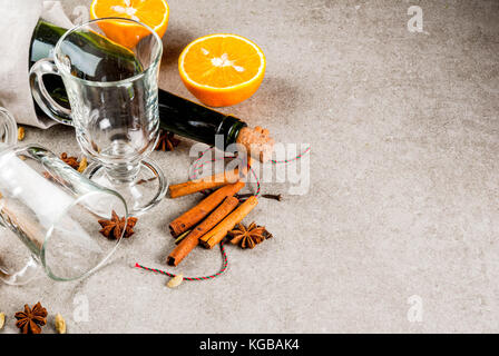 Weihnachten heiße Getränke Rezepte, von Zutaten für Glühwein: Wein Flasche, Glas Tassen, Gewürze, orange. grauen Stein Hintergrund Kopie Raum Stockfoto